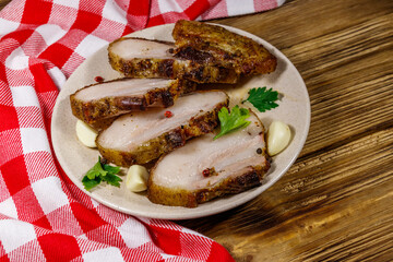 Baked pork belly in a plate on wooden table