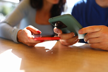Man and woman are holding smartphones in their hands. Gadget addiction and distrust in relationship...