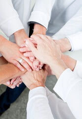 Close up top view of business people putting their hands together. Stack of hands. Unity and teamwork concept.