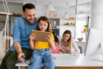 Happy family spending time at home and using digital, technology devices.