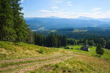 Fototapeta na wymiar Hiking trail to small house in the mountains. Wide angle view of mountain range and valleys. View to Hoverla and Petros peaks - highest points in Ukrainian Carpathians. Carpathian mountains, Ukraine.