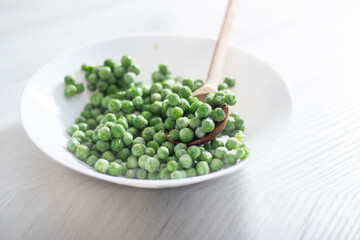 green peas in a white plate on a white background