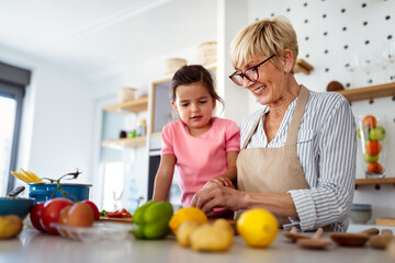 Grandmother and granddaughter are cooking on kitchen. Family fun love generation concept