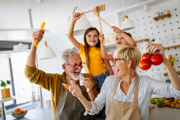 Portrait of happy elderly couple and grandchildren playing together