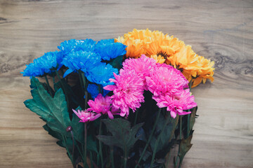 colorful flowers on a wooden table. place for text