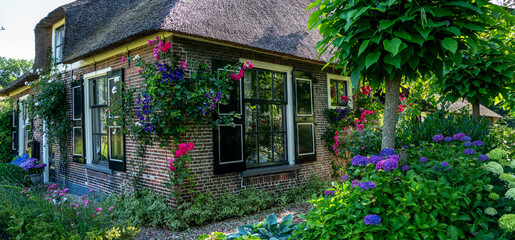 Fototapeta na wymiar Landscape view of typical houses of Giethoorn, Netherlands. Famous village is know as 