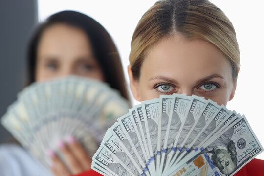 Women Are Holding Fan Of One Hundred Dollar Bills. High Earnings On The Internet Concept