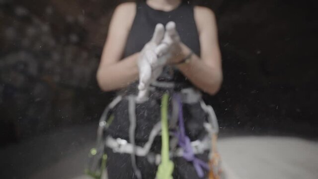 Rock climbing grip chalk dust applying by a climber girl 