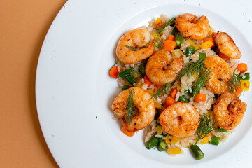 fried shrimp with vegetables and rice on white plate. beige background. top view. flat lay.