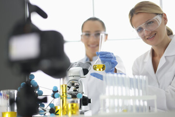Two researchers are filming experiments in laboratory on camera. Remote training and video content for blogger channel concept