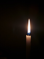long orange flame from candle in dark