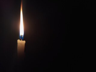 long orange flame from candle in dark