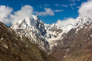 Fototapeta na wymiar Snow capped mountain peaks and glaciers at the high Himalayan pass of Kunzum La in the Spiti valley.