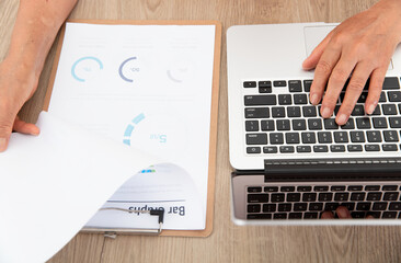 Experienced staff members use the computer while viewing financial information