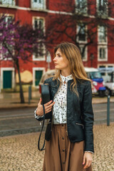 Obraz premium beautiful girl in stylish clothes with a small handbag in her hands