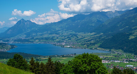 Panoramic view of idyllic scenery of Lake Lungern with fresh green meadows. Beautiful sunny day in springtime in Switzerland. Summer rural view. Village in green mountain valley.