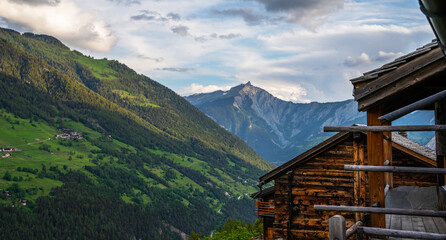 Fototapeta na wymiar Scenic view of beautiful Swiss Alps mountains. Canton du Valais, Switzerland. Picturesque Alpine village in background. Switzerland in summer. Alpine landscape