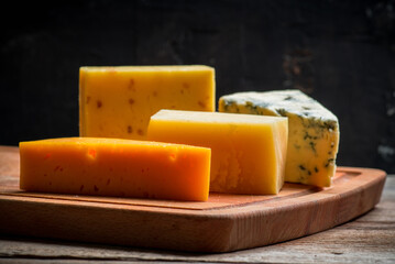 Different cheese on the old wooden table. Selective focus. Shallow depth of field. 
