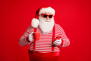 Fototapeta na wymiar Portrait of his he nice handsome cheery focused bearded fat overweight Santa wear costume drinking caffeine using device 5g app isolated bright vivid shine vibrant red color background