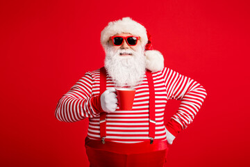 Portrait of his he nice attractive handsome cheerful cheery Santa drinking cacao latte holly jolly festal good mood isolated on bright vivid shine vibrant red color background
