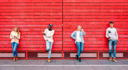 Multicultural friends group using smartphone by red wooden background - Technology and urban...