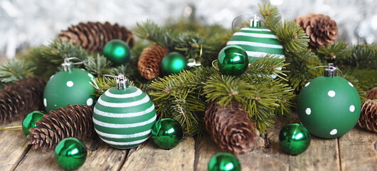 Christmas decorations green balls, fir branches on a wooden background with a shiny background....