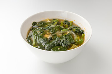 Spinach miso soup on a white background