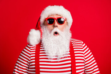 Close-up portrait of his he nice handsome attractive amazed stunned white-haired Santa christmastime sale wearing sunglasses isolated over bright vivid shine vibrant red color background