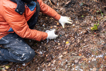 big amount of trash in forest, family father and son picking garbage away, global environment issues