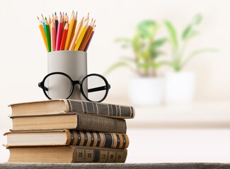 Stack of vintage books and colorful pencils on the desk