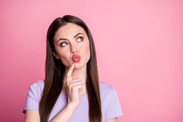 Closeup photo of charming lady long hairdo send boyfriend air kisses look up empty space finger cheek thinking creative idea wear casual purple t-shirt isolated pastel pink color background