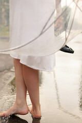 red-haired girl in a white dress with an umbrella after the rain