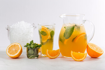 Orange and mint lemonade in a jug and glass