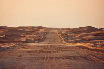 Empty desert road in the middle sand dunes
