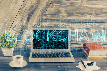 Double exposure of blockchain theme hologram and table with computer background. Concept of bitcoin crypto currency.