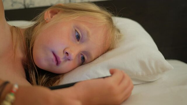 little girl uses a smartphone