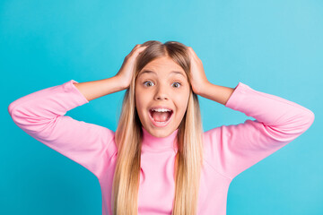 Photo portrait of shocked amazed blonde little girl shouting holding head with hands isolated on...