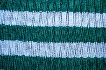 Texture of old green and blue striped knitted sweaters. Double ribbing stitch knit fabric background