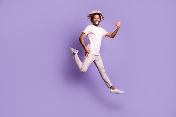 Fototapeta na wymiar Full size photo of young afro handsome excited cheerful positive man guy jump fly play invisible guitar isolated on purple color background