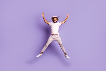 Fototapeta na wymiar Full size photo of young afro handsome excited happy cheerful man male guy jump fly raise hands isolated on violet color background