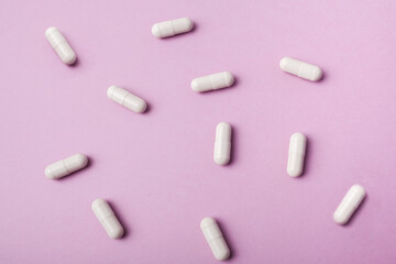Pills on a pink background. Biologically active additives.