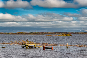 Flooded benches on a parking spot near Skjern in Denmark