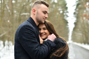 Fototapeta premium The concept of romance and love. Winter love story. smile, hugs and kiss of a couple in love.