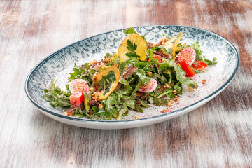 Duck breast salad with potato chips and fresh vegetables. On a decorative plate