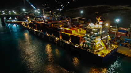 Container ship alongside the berth in Philpsburg Harbour - Saint Martin during nighttime cargo operations.