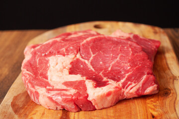 Premium rib eye steaks on a wooden cutting board, Top quality meat product with excellent marbling which gives it special flavor. Black background