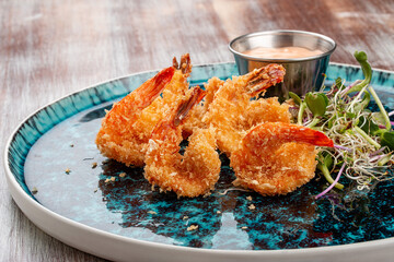Fried tiger prawns with sauce on a decorative plate