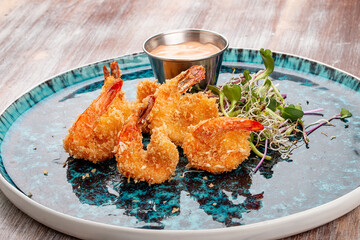 Fried tiger prawns with sauce on a decorative plate