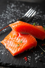 Pieces of smoked salmon on a black plate