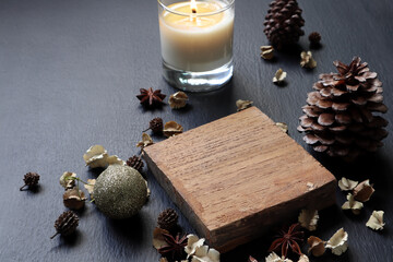 small wooden slats for display products is on the black wooden table decorate with scented candle and chirstmas ornaments during christmas new year celebration party theme